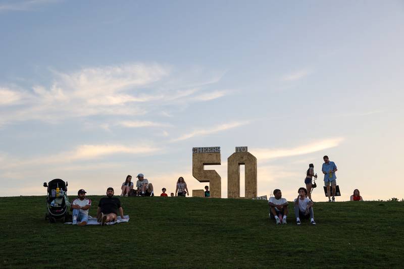 Attendees lounge on the hill as live music is performed during the 50th Bourbonnais Friendship Festival at The Grove on Saturday, June 28, 2025.