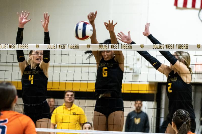 Joliet West's Lina Govoni, Faith Jordan, and Lexie Grevengoed block during a 4A sectional varsity volleyball game against Oswego at Joliet West on Nov. 4, 2025.