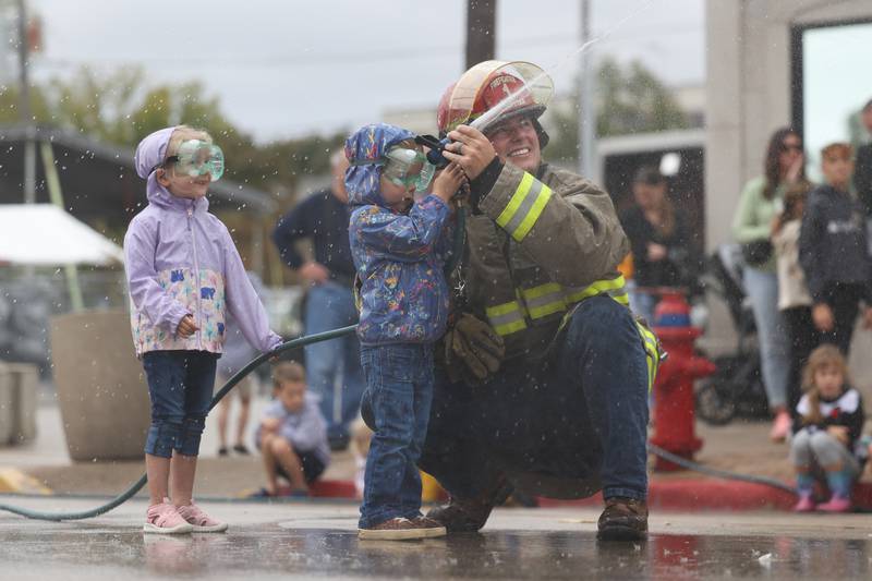 Trevor Delehanty, right, helps Sophie Brown, 3, and Adalyn Resler, 4, during the Kiddie Water Fight at the 75th Annual Grundy County Corn Festival on Saturday, Sept. 28, 2024 in downtown Morris.