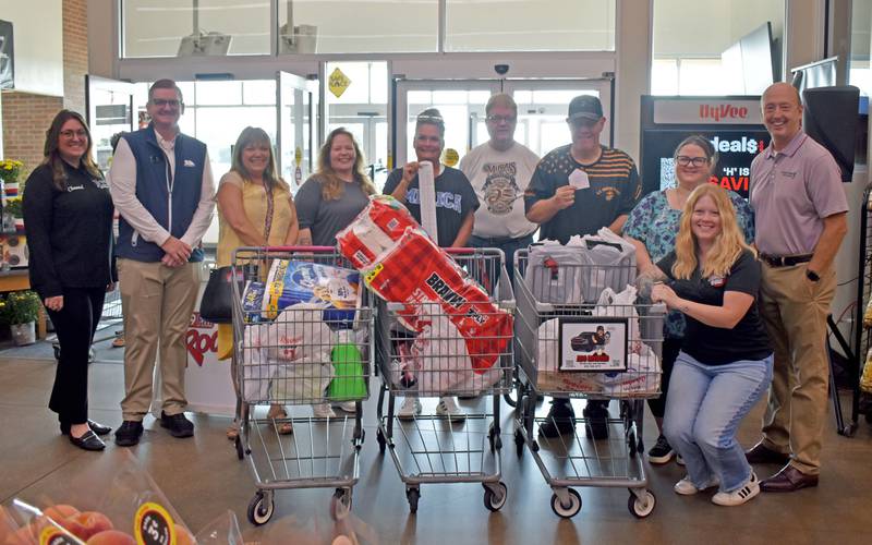 (From left) Chauntel Hauter, BJ Rissi, Rhonda Bezely, Jeanie Pelka, Michelle Duttlinger, E.J. Flanagan, Mark Schram, Amber Leibov, Dani Holland, and Dave Conterio pose for a photo during the Hometown National Bank “Hometown Hero” sweepstakes on Friday, Aug. 23, 2025 at Hy-Vee in Peru.