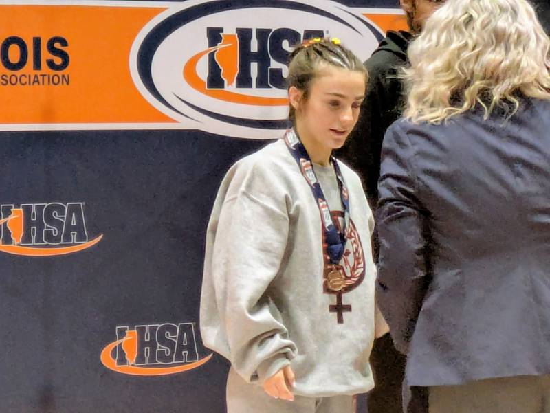 Batavia's Lily Enos receives her medal for taking fifth at 100 pounds at the IHSA Girls Wrestling State Tournament on Saturday, February 28, 2026, in Bloomington.