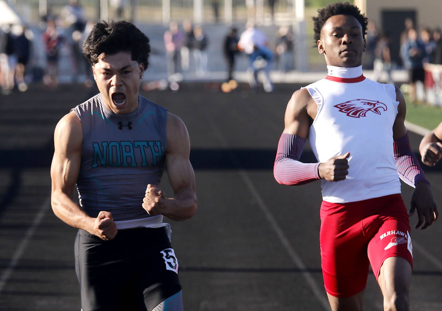 Woodstock North's Adan Castaneda celebrates winning the 100 meter dash over North Chicago’s Marlin Jeffries Jr. during the IHSA Class 2A Richmond-Burton Sectional Boys Track and Field Meet on Wednesday, May 20, 2026, at Richmond-Burton High School.