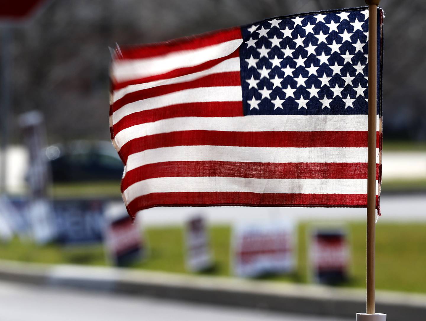 Campaign signs and a flag are posted outside of McHenry City Hall, a polling place during Tuesday's 2024 primary election.