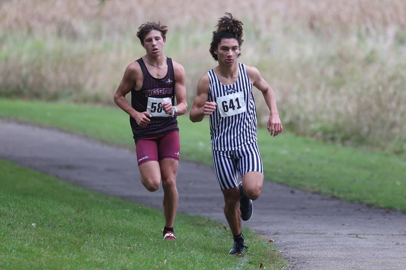Plainfield South’s Camyn Viger holds a slight lead over Plainfield North’s Owen Stahl in the Southwest Prairie Conference meet at Channahon Park in Channahon on Friday, Oct. 13, 2023.