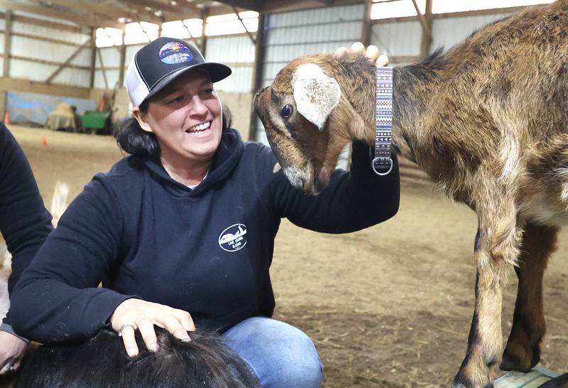 Didi Dowling, owner and executive director of Live, Learn and Lead, pets some of the baby goats Friday, March 31, 2023, at their barn in Hampshire.