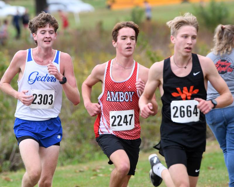 Amboy's Henry Nichols (center) follows Winnebago's Joseph Erb Jr. during the Amboy Columbus Day Cross Country Invitational held at Shady Oaks Country Club near Amboy on Monday, Oct. 13, 2025.