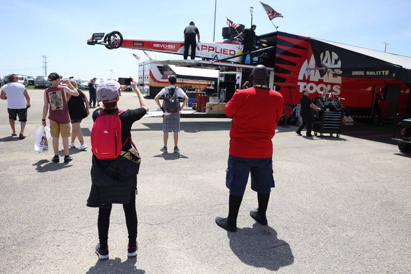 Race fans take photos as Doug Kalitta’s crew loads his car into the trailer at the NHRA’s Gerber Collision and Glass Route 66 Nationals at Route 66 Raceway on Sunday, May 19, 2024 in Joliet.