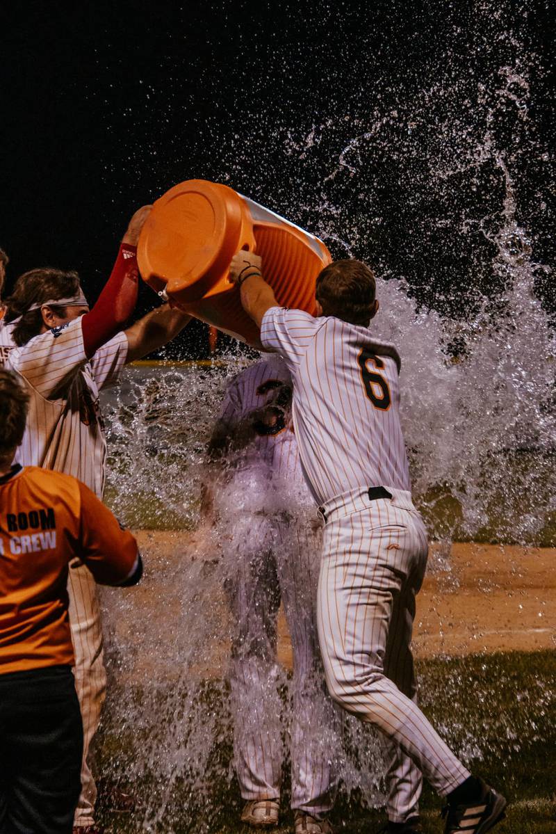 Nick Weaver gets doused with water after scoring the winning run on a wild pitch in the Illinois Valley Pistol Shrimp's 11-10, 10-inning victory over the Danville Dans on Thursday, July 18, 2024 at Schweickert Stadium in Peru.