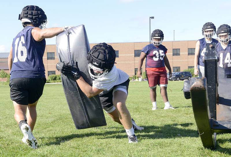 Oswego's offensive line works on blocking drills during a football practice at Oswego High School on Tuesday, August 7, 2022.