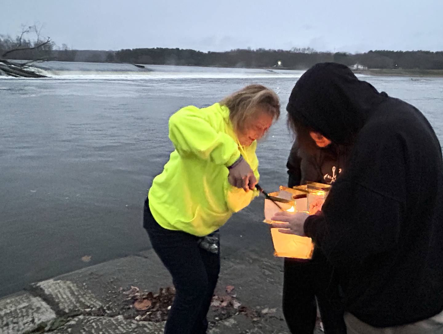 Penny Lee (left) lights lanterns for Jayson and Brooklynn Lindsey in memory of their nephew and cousin, Kent “Bud” Dearborn Jr., 33, of Polo, on Wednesday, Nov. 20, 2024, to commemorate the fifth anniversary of the fatal boating accident that took Bud's life and his fishing friend, James Swift, 64, of Forreston, in 2019. Swift's body was later recovered from the river in Dixon, but Dearborn's body has yet to be found.