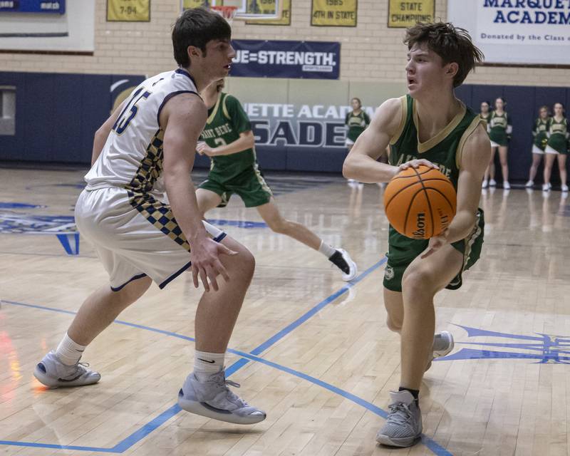 Carson Riva of St. Bede looks to pass to a teammate against Alec Novotney of Marquette during the game on January 10, 2025 at Marquette Academy.