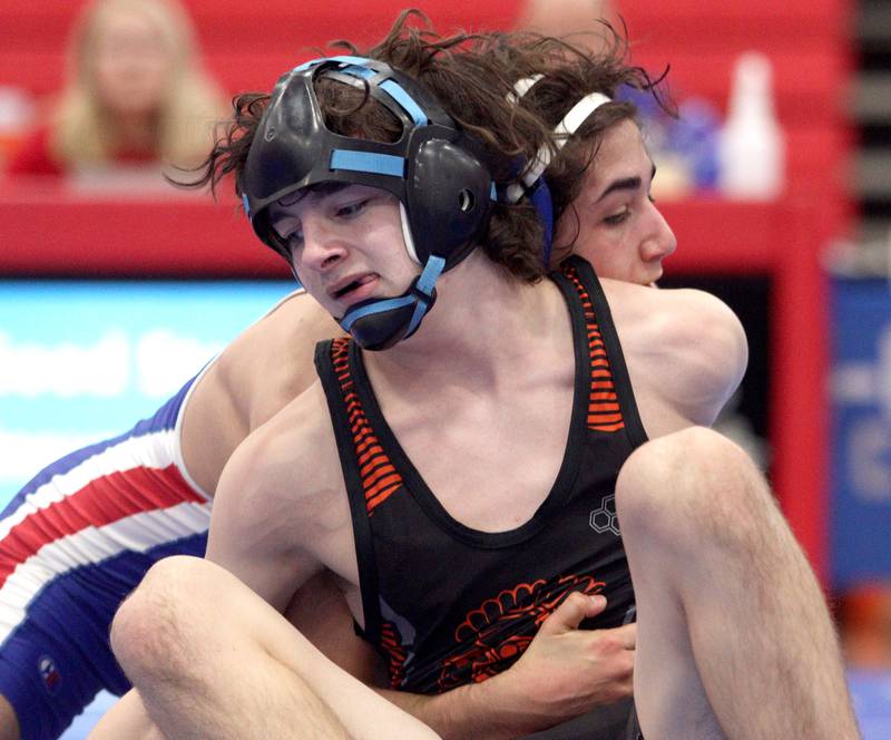 McHenry’s Zach Ference, front, battles Dundee-Crown’s Vinnie Velazquez in a 132-pound bout in varsity wrestling at Carpentersville Thursday night.