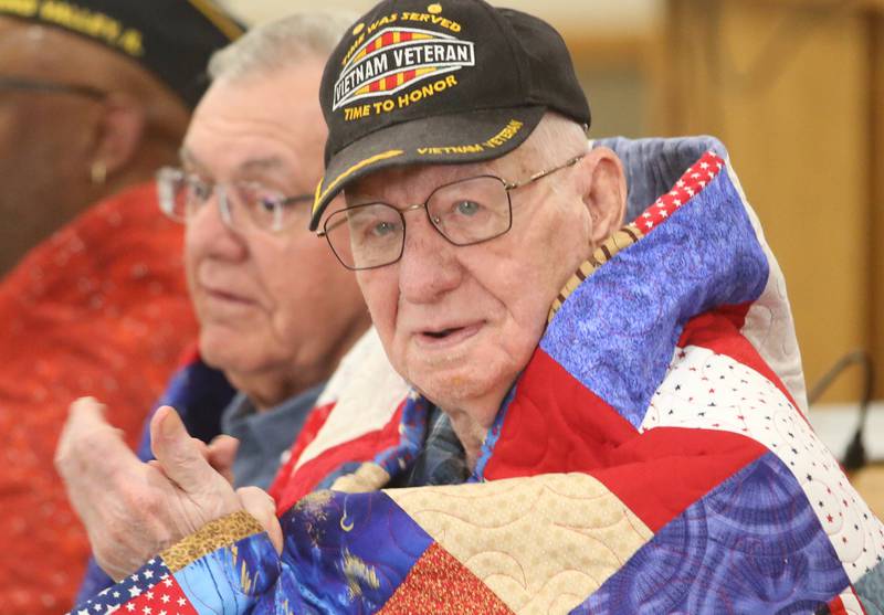 Veteran Doyle Finin, applauds while receiving his quilt during the Quilt of Valor ceremony on Saturday, April 19, 2025 at the Moose Lodge in Princeton.