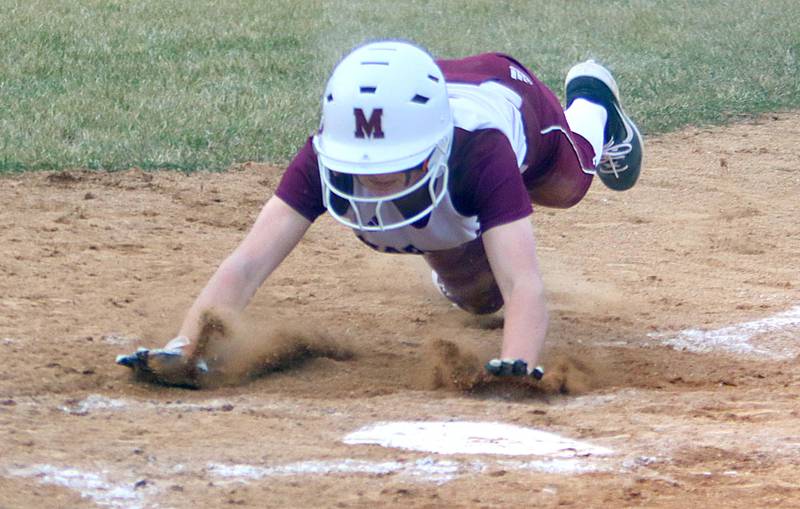 Marengo’s Madeline Christopher scores sliding during a win over Belvidere in varsity softball at Marengo on Monday.