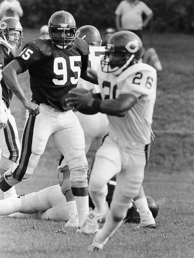 Chicago Bears defensive end Richard Dent (left) watches teammate fulback Matt Suhey run a play during training camp on Wednesday, June 12, 1985 in Platteville Wis.