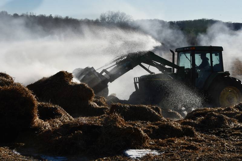 Firefighters from several departments responded to a field and hay bale fire at a farm on West Pines Road between Polo and Oregon on Monday, Feb. 23, 2026. Here, firefighters spray the bales with water as a tractor separates the bale.