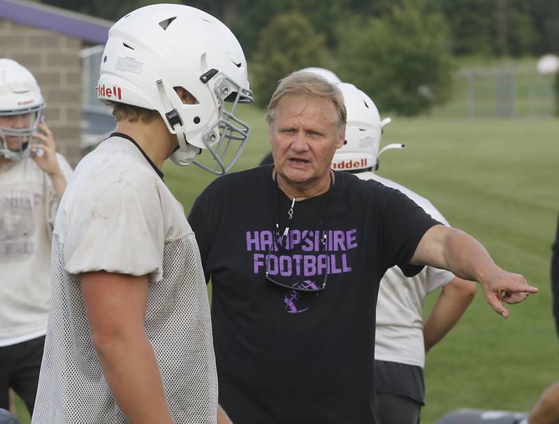 Hampshire football assistant coach Tim Haak teaches a player how she wants him to block during the first day of football practice Monday, August 7, 2023, at Hampshire High School.