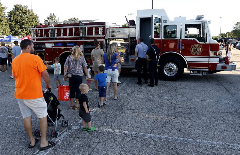 People line up to look at the McHenry Township fire truck during National Night Out! Tuesday, August 9, 2022, at Petersen Park in McHenry. The event was put on by the McHenry County Sheriff’s Office, City of McHenry Police Department and the McHenry County Conservation District and featured demonstrations, food and fun activities. National Night Out is held nationally in over 50,000 cities and is designed to help create relationships between neighbors and law enforcement community.