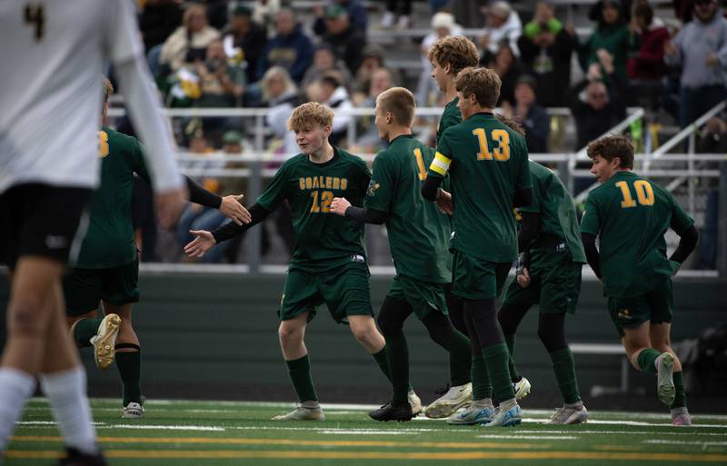 Coal City's Carter Hollis, center left, is congratulated on a goal in the first half of a sectional game against Herscher on Tuesday, October 28, 2025.