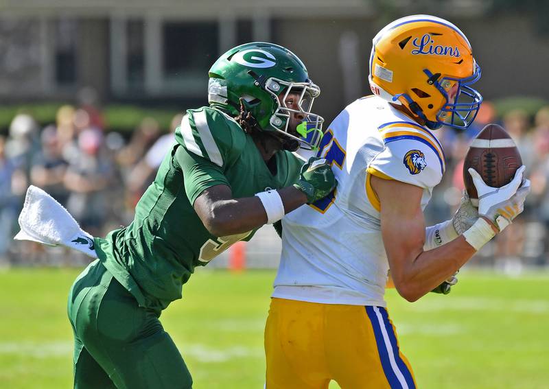 Lyons Township’s Grant Smith (right) is shoved out of bounds by Glenbard West’s Jaylen McMiller after a sideline catch during a game on September 27, 2025 at Glenbard West High School in Glen Ellyn.
