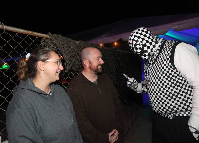Robyn Nix, of Antioch and her husband, Scott, are greeted by Robert Stang, of Volo (Checkers) before heading into the Realm of Terror Haunted House in Round Lake Beach.