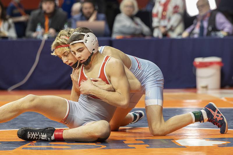 Marian Central’s Austin Hagevold and Vandalia’s Max Philpot (seated) compete in the 113 pound weight class of the 1A state individual wrestling finals Saturday, Feb. 22, 2025, at State Farm Center in Champaign.