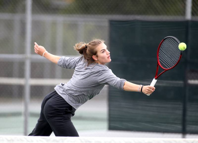 Oswego’s Savannah Millard reaches for the ball during the first day of the IHSA state tennis tournament at Fremd High School on Thursday, Oct. 20, 2022.