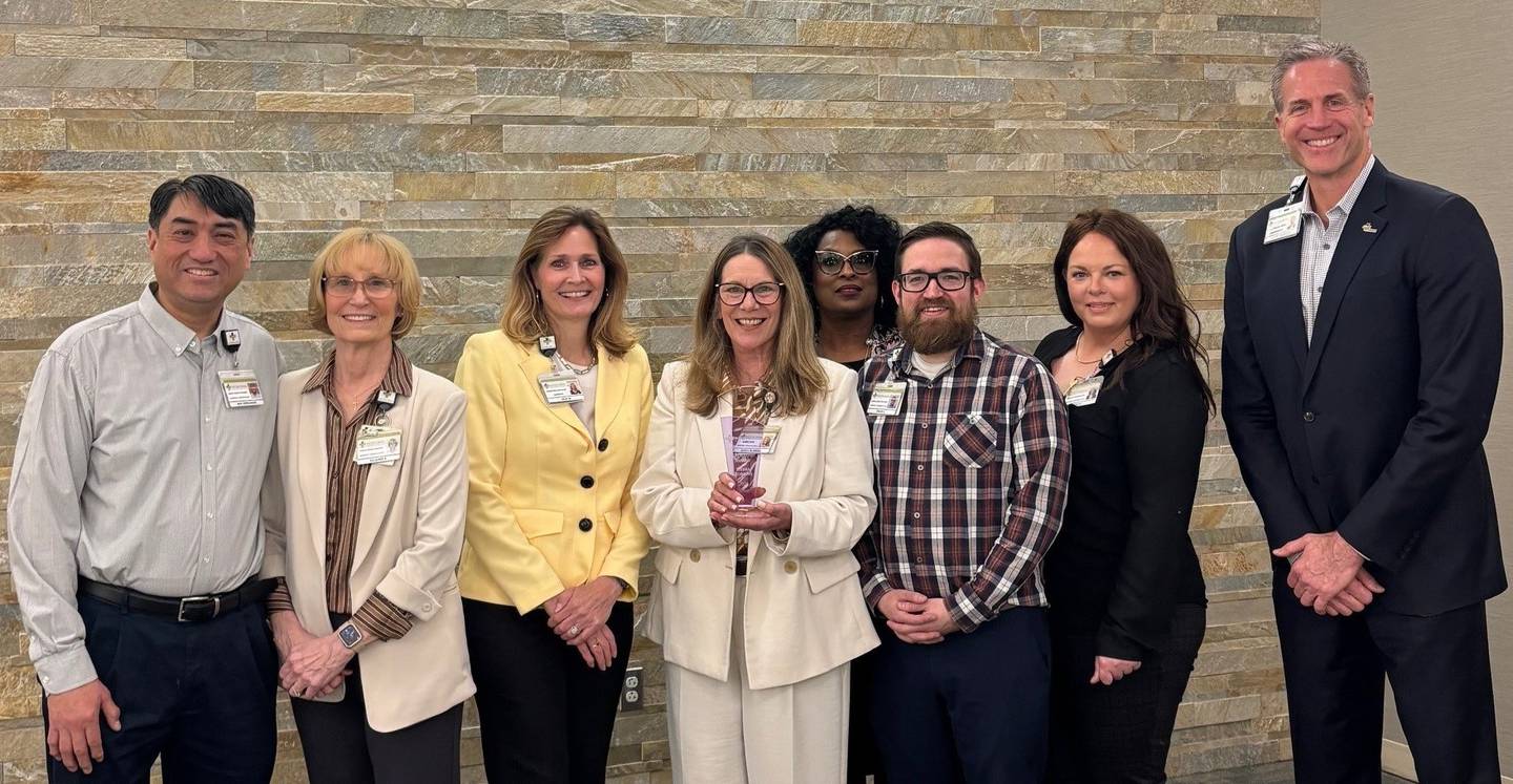 The Silver Cross Hospital Marketing and Communications Team includes (from left) Ben Hernandez, Suzanne Bies, Julie Mahoney, Debra Robbins, Leslie Newbon, Shaun Zinck, Neecie Jensen and Scott Paddock, senior vice president of external affairs. The team is seen on Thursday, April 23, 2026, at Silver Cross' leadership meeting when Robbins, the hospital's director of marketing and communications, received the 2026 Ruth Colby Leadership Award.