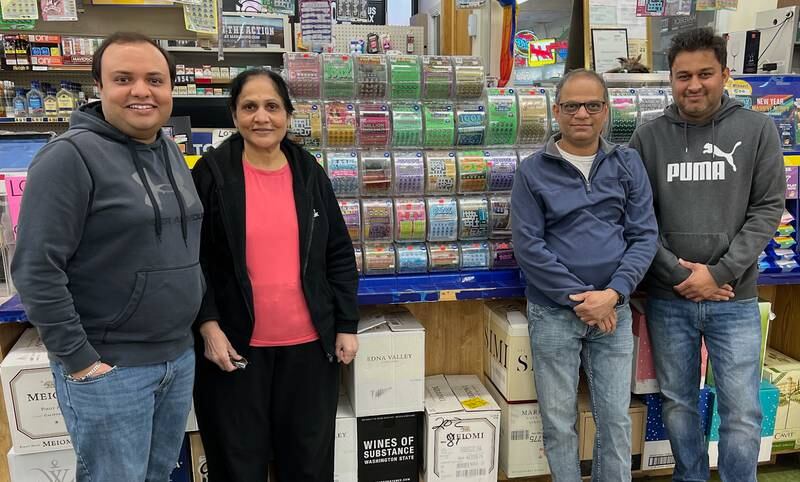 Dashank Desai and Mixa Desai (co-owners) of Stop 24 Liquors in Bolingbrook, sold a $1 million winning Lotto ticket to a customer. They
pose for a celebratory photo with store employees.