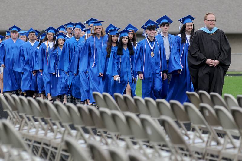 Graduates walk into the Woodstock High School football stadium Sunday, May 15, 2022, during the graduation ceremony in Woodstock.
