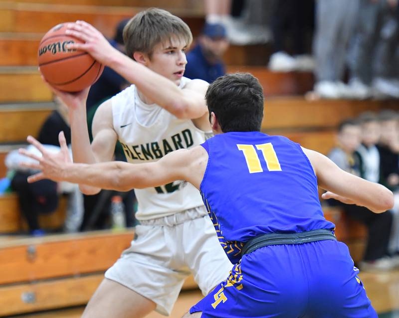 Lyons Township's Graham Smith (15) snags a loose ball in front of Glenbard West's Bennett Schwanke (21) during a game on Dec. 10, 2022 at Glenbard West High School in Glen Ellyn.