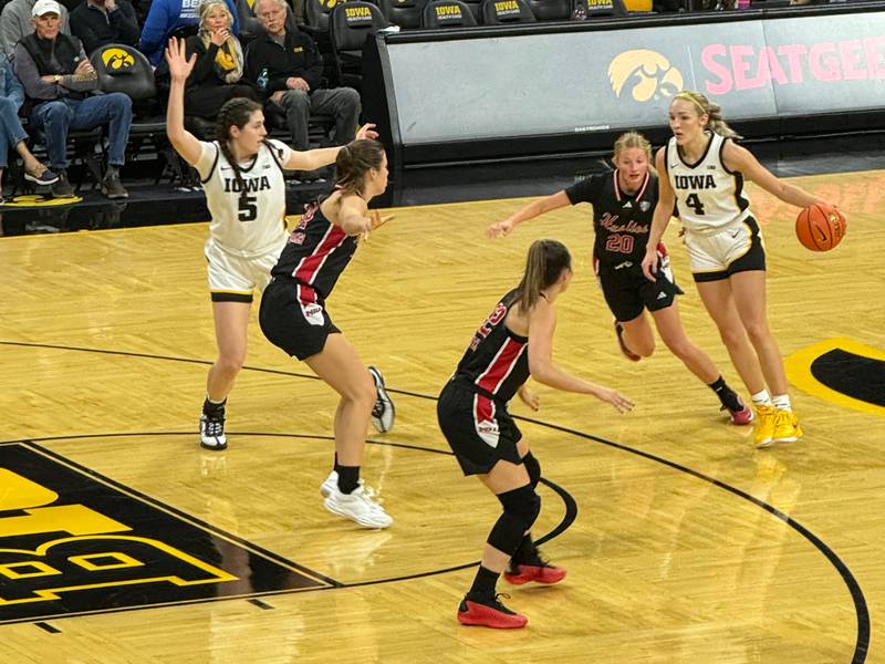 Iowa fifth-year senior and former Sycamore star Kylie Feuerbach dribbles while being guarded by NIU freshman and fellow Sycamore alum Lexi Carlsen during Wednesday's game in Iowa City.