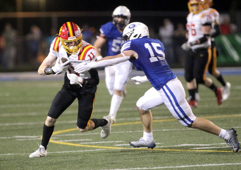 Batavia’s Patrick McNamara carries the ball as he’s wrapped up by Geneva’s Charlie Winterhalter during a game at Geneva on Friday, Sept. 29, 2023.