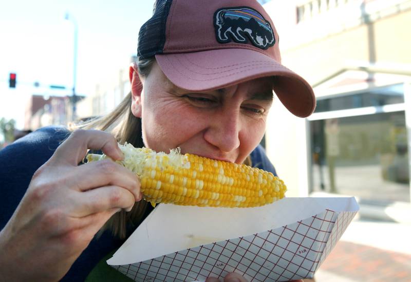 Stacy Maijala, who is in town from Marquette, Mich. visiting friends, samples some local sweet corn Friday, Aug. 23, 2024, during the DeKalb Corn Fest.