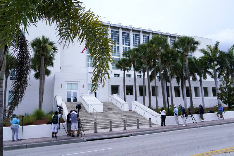 FILE - News media wait outside of the Alto Lee Adams Sr. U.S. Courthouse where their is a pretrial conference to discuss procedures for handling classified information in the case against former President Donald Trump, Tuesday, July 18, 2023, in Fort Pierce, Fla. A federal judge in Florida has set a trial date for next May for Trump in a case charging him with illegally retaining hundreds of classified documents. The May 20, 2024, trial date was set by U.S. District Judge Aileen Cannon. (AP Photo/Lynne Sladky, File)