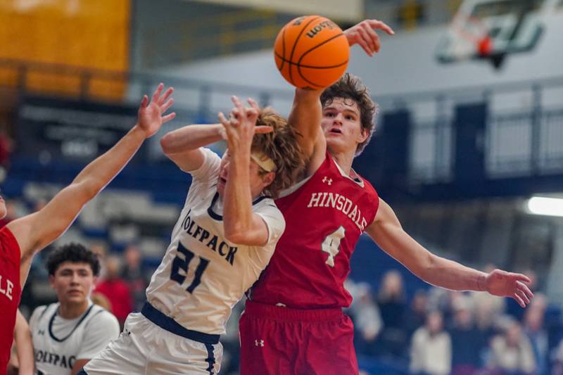 Hinsdale Central's Vincas Buzelis (4) blocks a shot by Oswego East's Andrew Pohlman (21) during a hoops for healing tournament basketball game at Oswego East High School on Tuesday, Nov. 26, 2024.