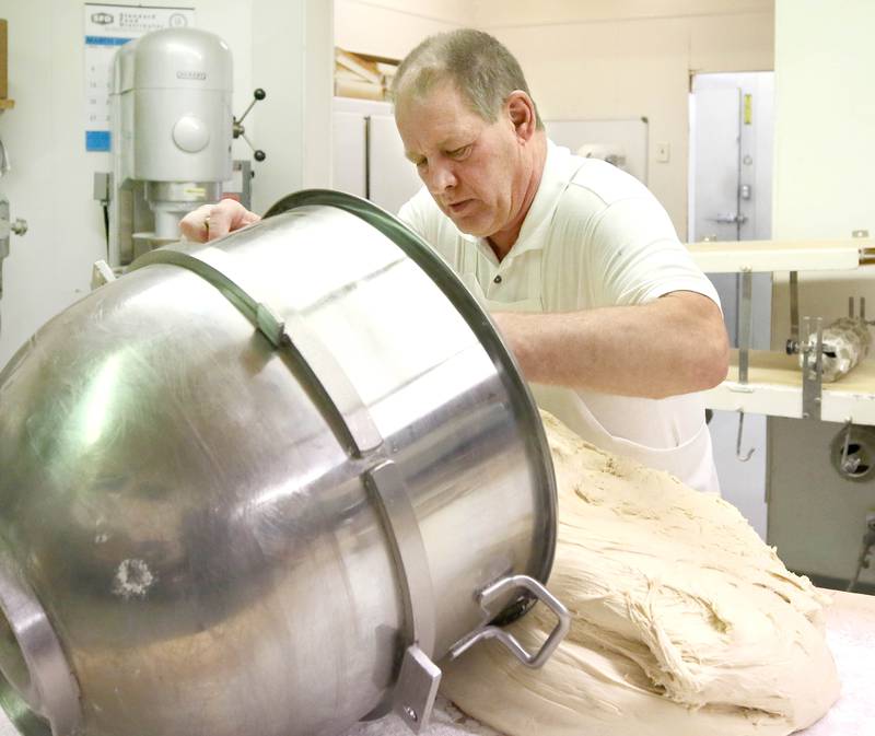 Ken Elleson, owner of Elleson's Bakery, pours out dough for paczkis Monday, Feb. 28, 2022, in the kitchen of the bakery in Sycamore. Elleson and members of his family will be working all night making the paczkis from scratch to be ready at 5 a.m. tomorrow for Fat Tuesday.