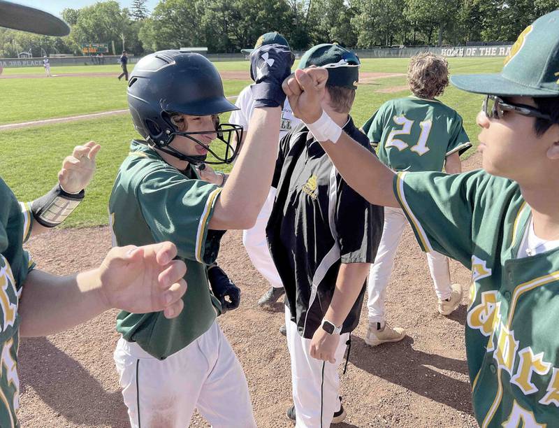 Crystal Lake South's Mason Struck is greeted by teammates after being knocked in during the IHSA Class 3A sectional semifinals, Thursday, June 2, 2022 in Grayslake.