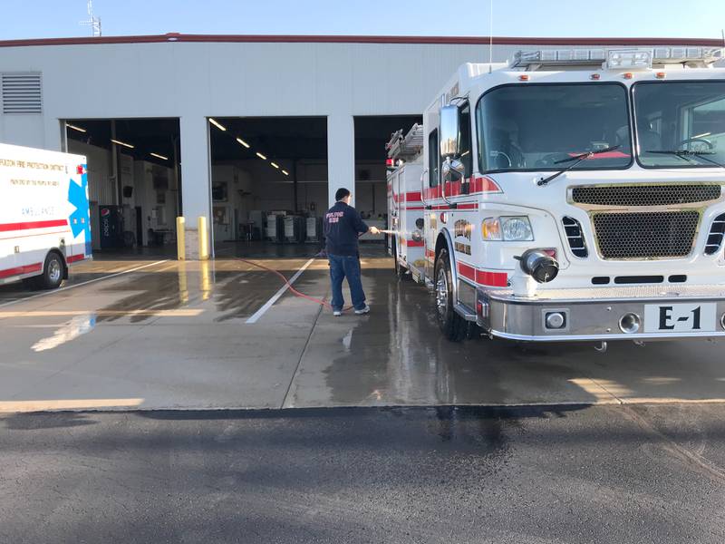 Firefighter and paramedic Steve Myers is pictured hosing down a fire truck at the Fulton Fire Department on Thursday, April 21.