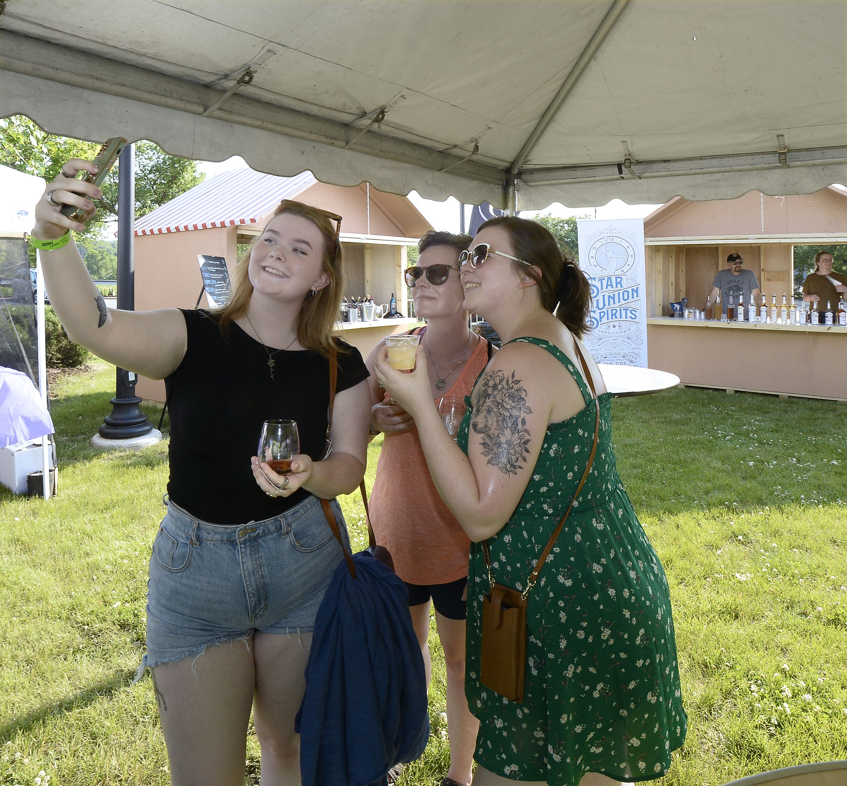 Evelyn Coyle, Heather Coyle and Mackenzie Beck take a souvenir photo of themselves Friday, June 2, 2023, during opening night of the 2 Rivers Wine Fest in Ottawa.