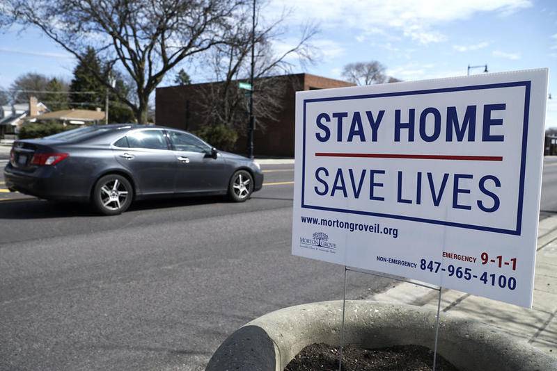 A sign encouraging people to stay home is seen in Morton Grove, Ill. Sunday, April 5, 2020, amid the  coronavirus outbreak.
