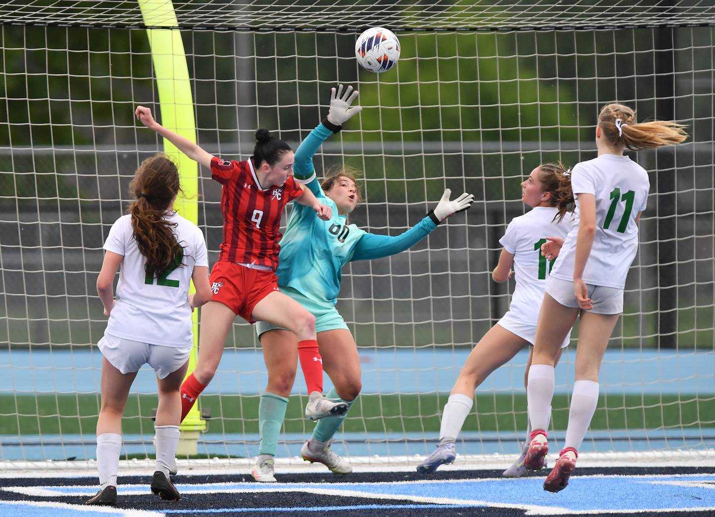 York goalkeeper Ava Lewandowski (00) reaches for the ball as Hinsdale Central’s Caitlin Doherty (9) makes contact during the Class 3A Downers Grove South Sectional final game on May 30, 2025 at Downers Grove South High School in Downers Grove .