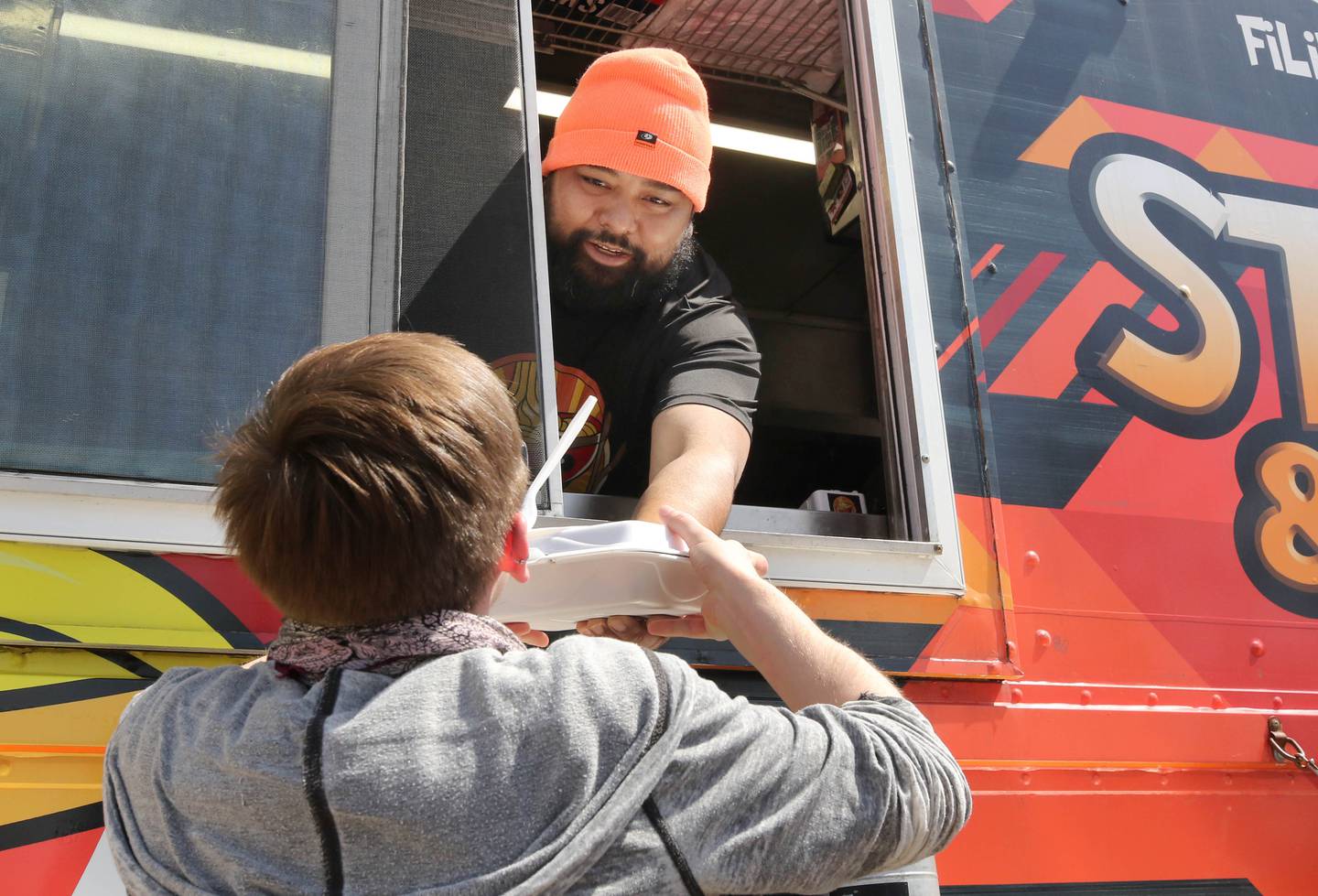 Cherwin Calara, from Stix and Noodles, fills an order Wednesday, April 10, 2024, during Food Truck Wednesday at Northern Illinois University. Food trucks, entertainment and games will all be available on campus from 11 a.m. to 2 p.m. on Food Truck Wednesdays.