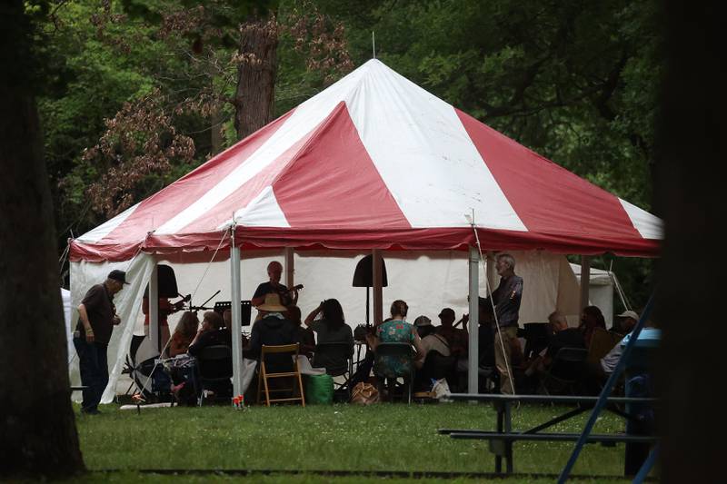 A group gathers to play music at the Jam Session tent at the Gebhard Woods Dulcimer & Traditional Music Festival on Saturday June 8, 2024 in Morris.