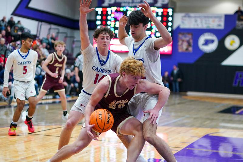 Morris’ RJ Kennedy (20) plays the ball on the baseline while being defended by Marmion’s Brendan Kavanaugh (left) and Samuel Dalmann (right) during a basketball game in the opening round of the 61st annual Plano Christmas Classic at Plano High School on Monday, December 23, 2024.