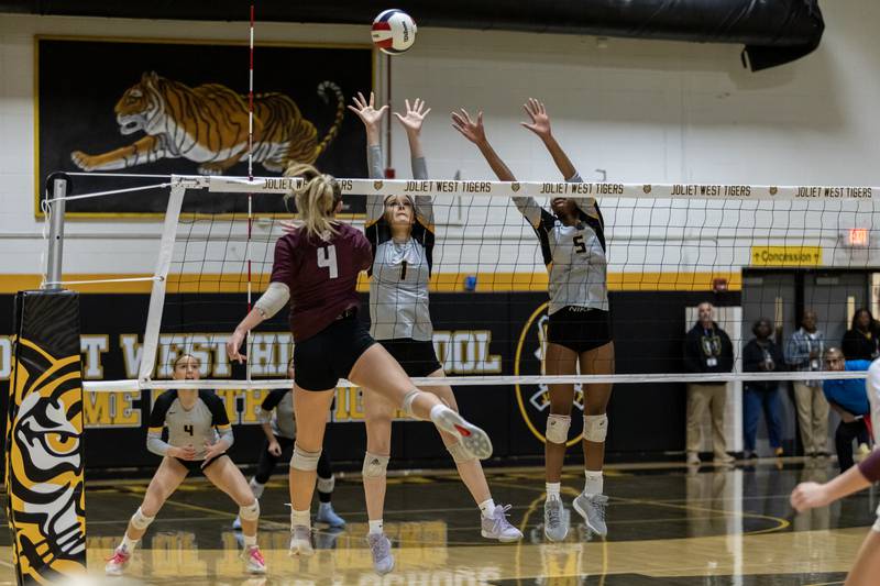 Joliet West's Emma Salerno and Joliet West's Mady Gant attempt to block a hit from Lockport's Mikayla Marshall during a 4A Sectional Finals varsity volleyball game at Joliet West on Nov. 6, 2025.
