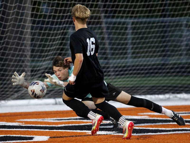 Prairie Ridge's Christopher Zinevich makes a diving save as McHenry's Cody Bundy tries to get to the ball during a Fox Valley Conference boys soccer match on Tuesday, Sept. 30, 2025, at McCracken Field in McHenry.