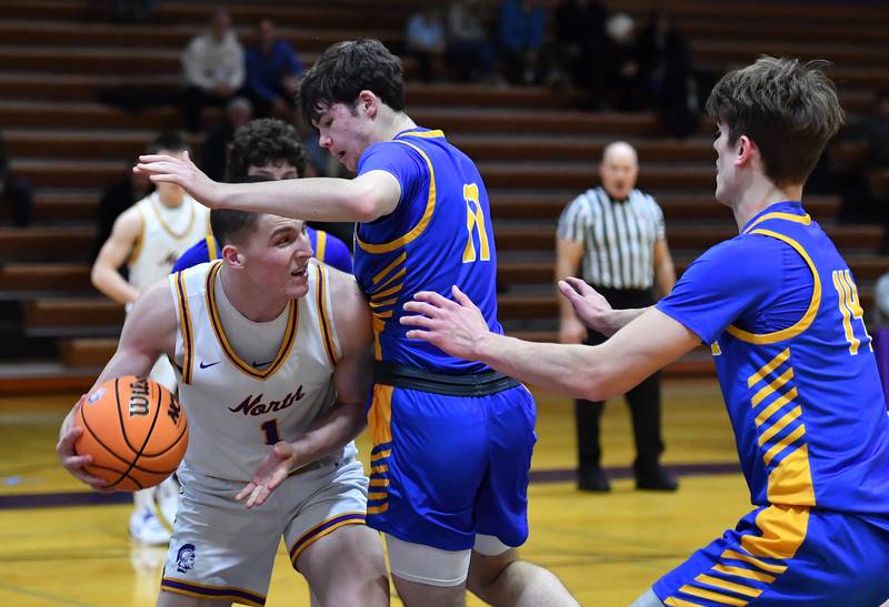 Downers Grove North’s Colin Doyle (1) looks for an open teammate as Lyons Township’s Tommy Blyth and Grant Smith (right) defend during a game on January 15, 2026 at Downers Grove North High School in Downers Grove .