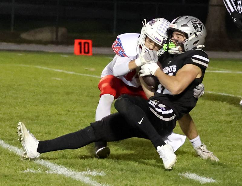 Kaneland's Brady Brown catches a long pass despite the coverage of Lakes’ Dominick Lostroscio Saturday, Nov. 1, 2025, during their first round playoff game at Kaneland High School in Maple Park.
