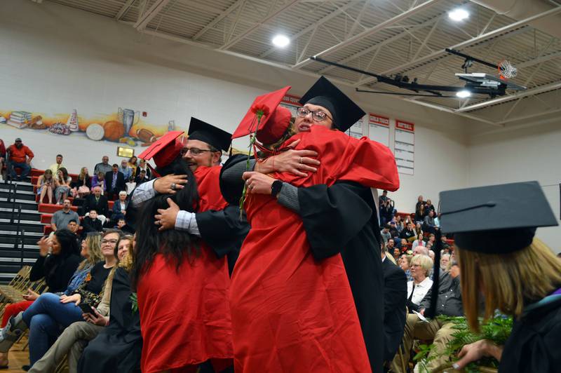 Forreston High School seniors Carli Hollis, left, and Sydney Greenfield, right, hug teachers as the Class of 2023's commencement nears its conclusion on May 14, 2023. Hollis and Greenfield both plan to study nursing at Highland Community College.